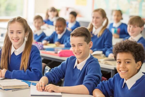 Primary pupils seated in classroom and smiling