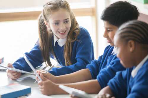 Three UK school children sat at desk