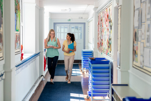 Two teachers walking down a corridor