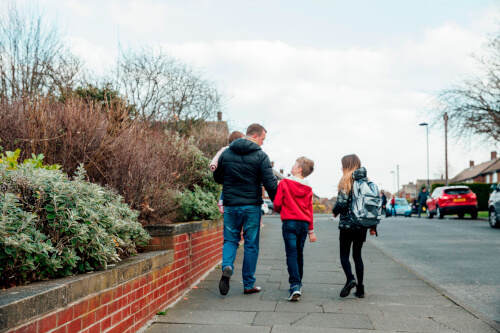 man walking children home from school