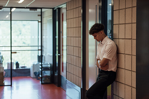 School boy leaning against wall