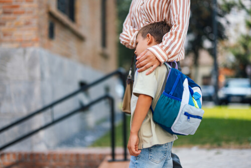 Small child with mother at school gates